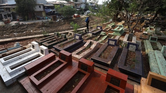 Petugas membersihkan area kompleks Makam Pangeran Jayakarta, Jakarta, Rabu (18/9). [Suara.com/Angga Budhiyanto]

