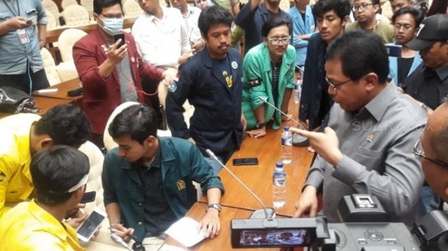 Aksi mahasiswa yang menolak revisi UU KPK dan RUU KUHP di depan gedung DPR RI, Kamis (19/9/2019), masih berlangsung hingga pukul 19.55 WIB malam. [Suara.com/Novian Ardiansyah]