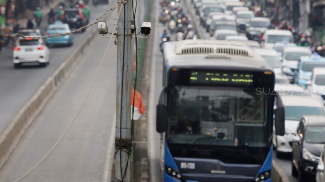 Sejumlah kendaraan melintas di jalur bus Transjakarta yang terpasang kamera pengawas (CCTV) di kawasan Pasar Rumput, Jakarta, Kamis (19/9). [Suara.com/Angga Budhiyanto]