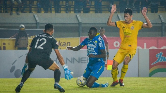 Pemain Persib Bandung Ezechiel Ndouasel (tengah) dijatuhkan pesepak bola Semen Padang FC Syaeful Anwar (kanan) pada laga lanjutan Liga 1 di Stadion Si Jalak Harupat, Kabupaten Bandung, Jawa Barat, Rabu (18/9/2019). Pertandingan berakhir imbang 1-1. ANTARA FOTO/Raisan Al Farisi