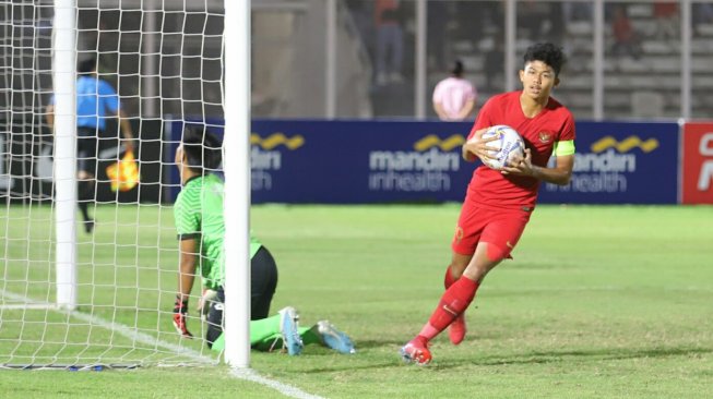 Pemain Timnas Indonesia U-16 Ahmad Athallah mengambil bola usai mencetak gol ke gawang Timnas Brunei Darussalam U-16 pada laga Kualifikasi Piala AFC U-16 2020 di Stadion Madya, Jakarta, Jumat (20/9). Timnas Indonesia U-16 menang dengan skor 8-0. [Suara.com/Arya Manggala]