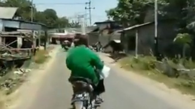 Bawa Botol di Atas Kepala, Pemotor Ini Bikin Pengendara Lain Noleh Dua Kali