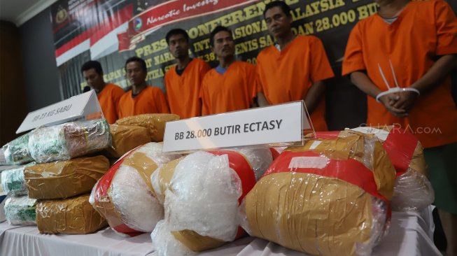 Petugas menunjukkan tersangka dan barang bukti berupa narkoba jenis sabu dan ekstasi saat rilis kasus penggagalan penyelundupan narkoba dari Malaysia di Bareskrim Polri, Jakarta, Jumat (20/9). [Suara.com/Angga Budhiyanto]