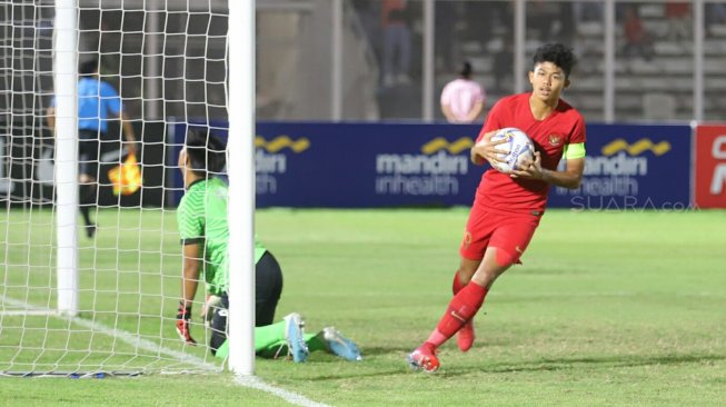 Pemain Timnas Indonesia U-16 Ahmad Athallah mengambil bola usai mencetak gol ke gawang Timnas Brunei Darussalam U-16 pada laga Kualifikasi Piala AFC U-16 2020 di Stadion Madya, Jakarta, Jumat (20/9). [Suara.com/Arya Manggala]