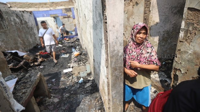 Warga mengamati sisa kebakaran permukiman di kawasan Balimester, Jatinegara, Jakarta, Sabtu (21/9). [Suara.com/Arya Manggala]