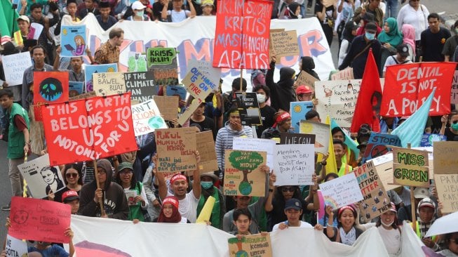 Aktivis dari berbagai organisasi lingkungan berjalan menuju Taman Aspirasi Monas saat aksi terkait krisis iklim di Jalan Medan Merdeka Barat, Jakarta Pusat, Jumat (20/9). [Suara.com/Arya Manggala]