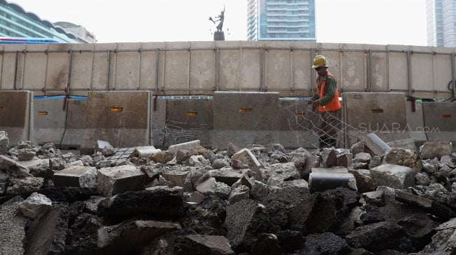 Pekerja menyelesaikan proyek revitalisasi trotoar di sekitaran Bundaran Hotel Indonesia, Jakarta, Minggu (22/9). [Suara.com/Angga Budhiyanto]
