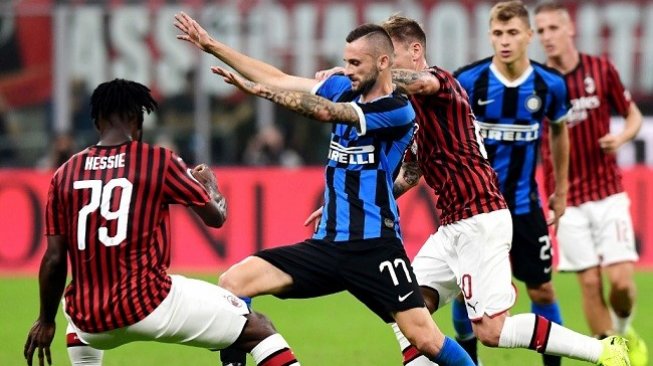 Gelandang jangkar Inter Milan, Marcelo Brozovic mencoba melewati adangan para pemain AC Milan. Inter sukses mengalahkan Milan 2-0 di laga lanjutan Serie A, Minggu (22/9/2019) dini hari WIB. (AFP)