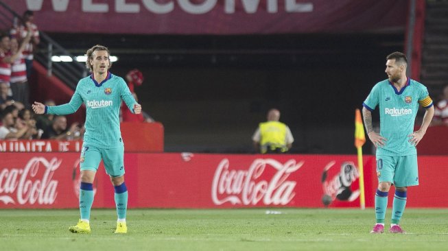 Pemain depan Barcelona Antoine Griezmann bersama pemain depan Barcelona Lionel Messi bereaksi terhadap gol kedua Granada selama pertandingan sepak bola liga Spanyol antara Granada melawan Barcelona di Stadion Nuevo Los Carmenes, Granada, Spanyol, Minggu (22/9) dini hari WIB. [GUERRERO JORGE / AFP]