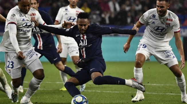 Penyerang PSG, Neymar menendang bola saat menghadapi Olympique Lyon pada lanjutan Liga Prancis 2019/20 di Stadion Parc Olympique Lyonnais, Senin (23/9/2019) dini hari WIB. (JEFF PACHOUD / AFP)