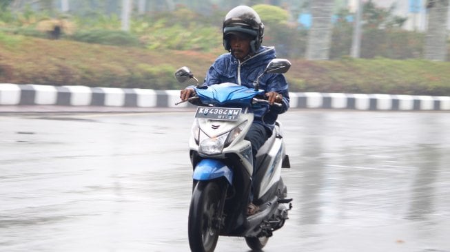 Pengendara sepeda motor melintasi Jalan Rahadi Oesman yang basah setelah hujan turun, di Pontianak, Kalimantan Barat, Senin (23/9). [ANTARA FOTO/Jessica Helena Wuysang]