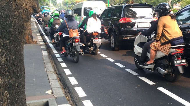 Jalur khusus sepeda di Jalan Imam Bonjol, Jakarta Pusat, diserobot oleh pengendara sepeda motor, Senin (22/9).[Suara.com/Oke Atmaja]