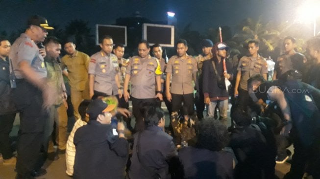 Rombongan mahasiswa yang sempat masuk dan bertahan di halaman dalam Gedung DPR RI, Senin (23/9/2019) malam, saat berbicara dengan petugas. [Suara.com / Novian Ardiansyah]