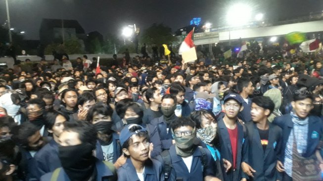 Ribuan mahasiswa yang melakukan aksi menolak revisi UU KPK yang baru disahkan DPR RI dan RUU KUHP memilih bertahan hingga malam hari di depan Gedung DPR RI, Senayan, Jakarta, Senin (23/9/2019). (Suara.com/Novian)