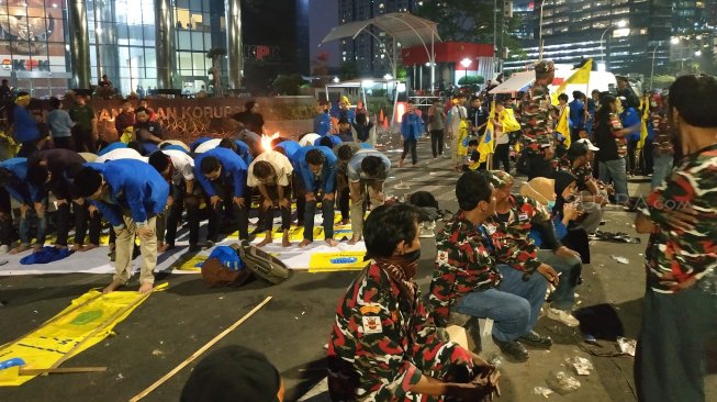 Sebagian massa pro revisi UU KPK salat Maghrib berjamaah di depan Gedung KPK. (Suara.com/Fakhri Fuadi)