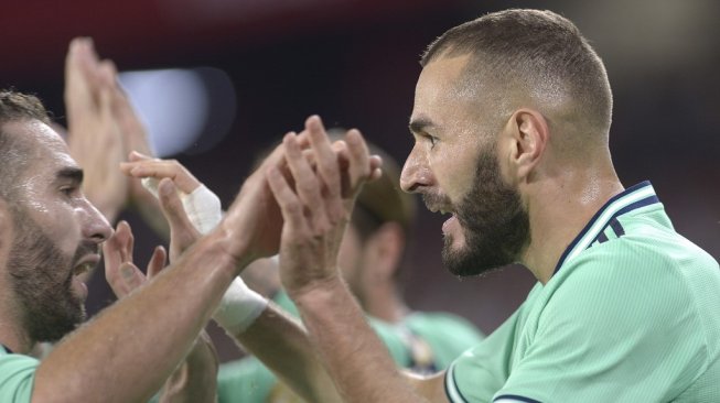 Penyerang Real Madrid, Karim Benzema, saat merayakan golnya. [CRISTINA QUICLER / AFP]