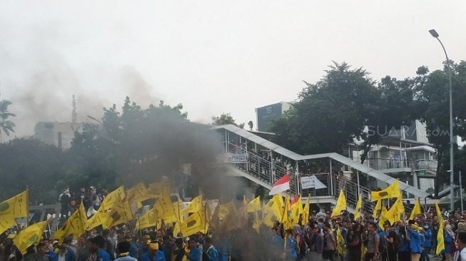 Pengunjuk rasa melakukan tindakan pelemparan kayu ke gedung KPK. (Suara.com/Fakhri).