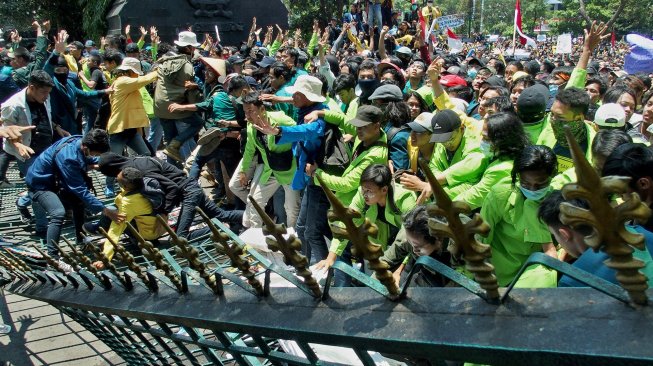 Mahasiswa dari berbagai perguruan tinggi merobohkan gerbang Gedung DPRD Jateng saat berunjuk rasa menolak UU KPK hasil revisi dan RUU KUHP, di Semarang, Jawa Tengah, Selasa (24/9). [ANTARA FOTO/R. Rekotomo]
