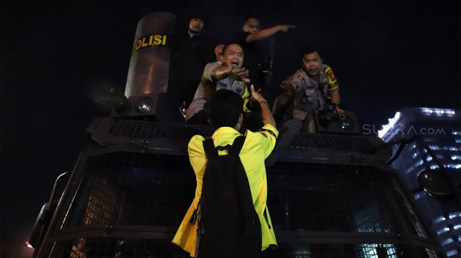 Seorang mahasiswa tampak berkomunikasi dengan petugas kepolisian saat aksi unjuk rasa di depan gedung DPR RI, Jakarta, Senin (23/9/2019). [Suara.com / Angga Budhiyanto]