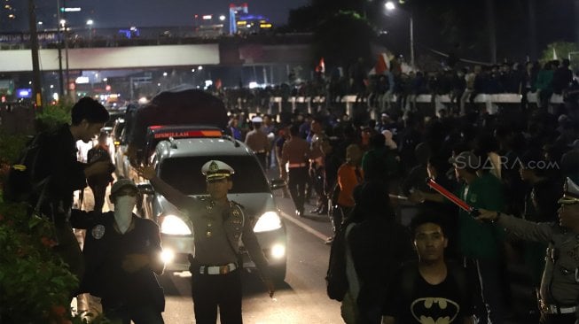 Sejumlah mahasiswa sempat mencoba memblokade jalan tol dalam kota saat berunjuk rasa di depan gedung DPR RI, Jakarta, Senin (23/9/2019), yang kemudian diuraikan lagi oleh petugas polisi. [Suara.com / Angga Budhiyanto]