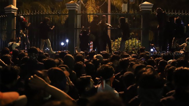 Sejumlah mahasiswa mencoba memanjat dan merusak pagar saat aksi unjuk rasa mahasiswa di depan gedung DPR RI, Jakarta, Senin (23/9/2019). [Suara.com / Angga Budhiyanto]