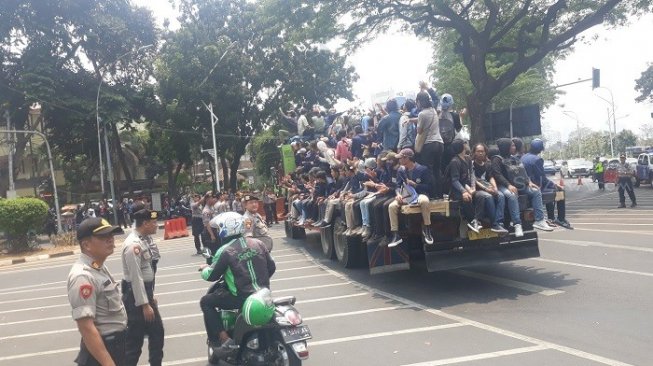 Puluhan mahasiswa saat mengompreng truk tronton untuk berdemo di depan DPR RI. (Suara.com/Novian).