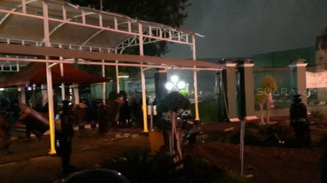 Polisi saat melepaskan gas air mata untuk membubarkan mahasisa di belakang gedung DPR, Senayan. (Suara.com/Novian).