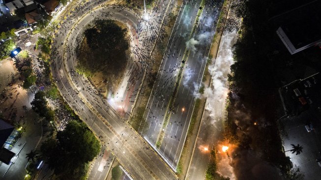 Foto udara saat Polisi membubarkan massa mahasiswa yang demo menolak UU KPK dan RUU KUHP yang berakhir ricuh di Jalan Tol Slipi, Senayan, Jakarta, Rabu. (24/9). [ANTARA FOTO/Hafidz Mubarak]