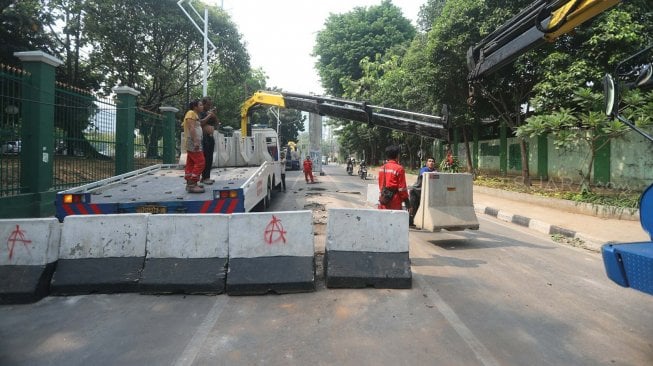 Petugas menutup Jalan Gelora di belakang Gedung DPR, Jalan Gelora, Senayan, Jakarta, Rabu (25/9). [Suara.com/Arya Manggala]
