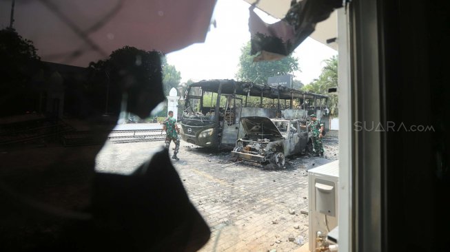 Bus TNI yang hangus terbakar pasca unjukrasa mahasiswa di Jalan Gelora, Senayan, Jakarta, Rabu (25/9). [Suara.com/Arya Manggala]
