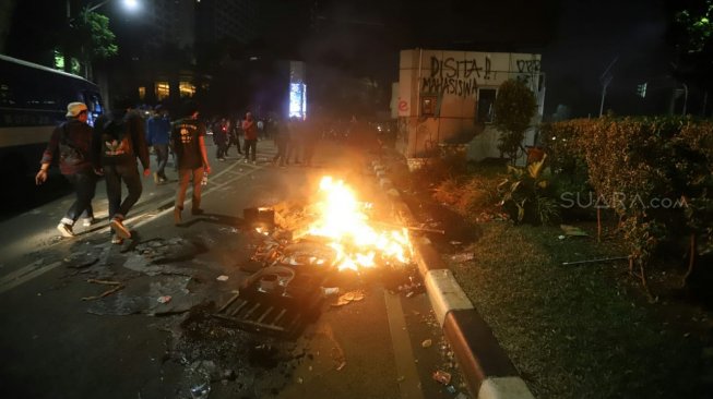 Pos Polisi dibakar saat aksi menolak UU KPK yang berakhir ricuh di Jalan Gerbang Pemuda, Senayan, Jakarta, Selasa (24/9). [Suara.com/Arya Manggala]