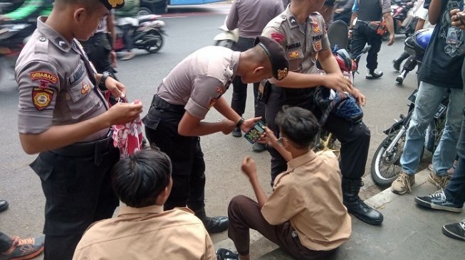 Polisi sweeping para pelajar yang hendak berdemo ke gedung DPR RI. (Suara.com/Arga).