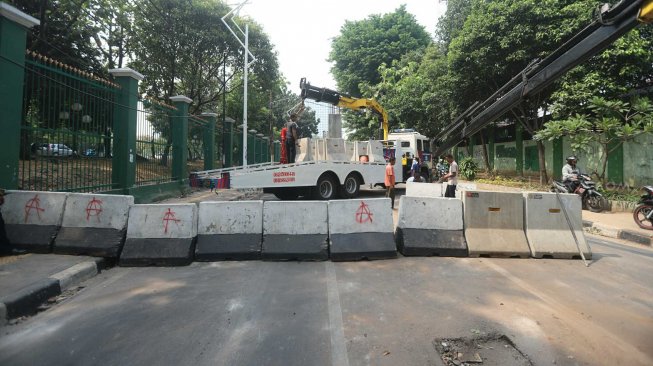 Petugas menutup Jalan Gelora di belakang Gedung DPR, Jalan Gelora, Senayan, Jakarta, Rabu (25/9). [Suara.com/Arya Manggala]
