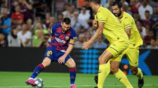 Kapten Barcelona, Lionel Messi, mengecoh sejumlah pemain Villareal pada lanjutan Liga Spanyol 2019/20 di Stadion Camp Nou, Rabu (25/9/2019). [LLUIS GENE / AFP]