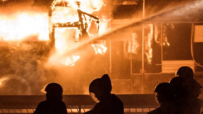 Bus TNI terbakar ricuh di halaman parkir Lapangan Tembak, Senayan, Jakarta, Selasa (24/9) malam. [ANTARA FOTO/Sigid Kurniawan]