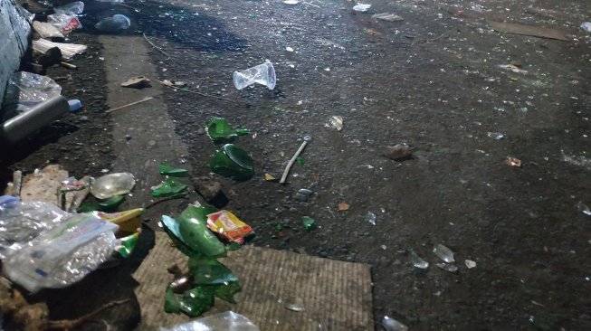 Pecahan botol berserakan di Palmerah, Jakarta setelah demonstrasi berakhir pada Rabu malam (25/9/2019). [Suara.com/Fakhri Fuadi]