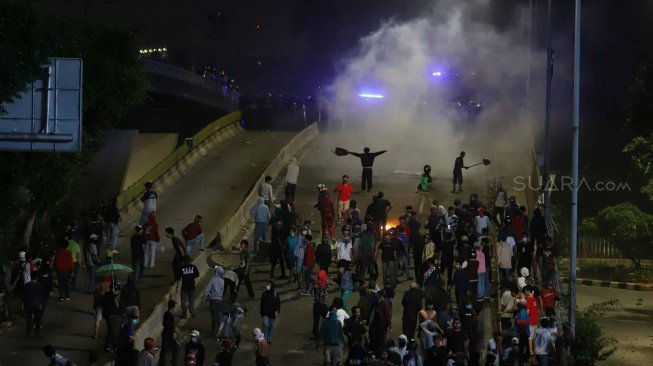 Pelajar menghindari gas air mata saat terlibat bentrok dengan polisi ketika melakukan aksi unjuk rasa di kawasan Jalan Layang Slipi, Jakarta, Rabu (25/9). [Suara.com/Arya Manggala]