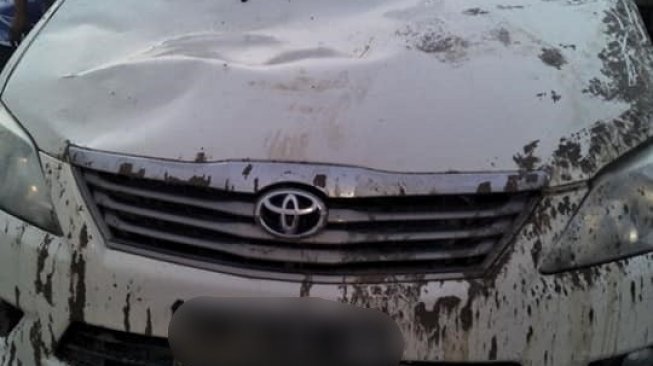 Mobil Kijang Innova yang terkena tumpahan adonan semen. (Facebook/Karimul Fuad)