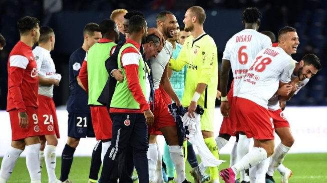 Para pemain Stade Reims merayakan kemenangan tim saat menundukkan PSG pada pekan ke-7 Ligue 1 2019/20 di Stadion Parc des Princes, Kamis (26/9/2019). (Bertrand GUAY / AFP)