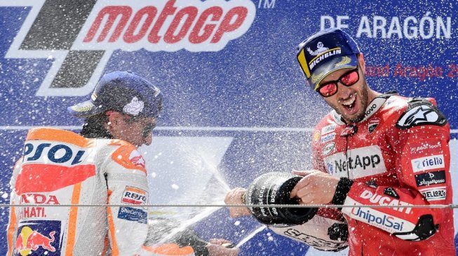 Pebalap Repsol Honda, Marc Marquez (kiri), merayakan keberhasilan menjuarai MotoGP Aragon di Sirkuit Motorland bersama rider Ducati, Andrea Dovizioso, yang finis kedua, Minggu (22/9/2019). [AFP/Javier Soriano]