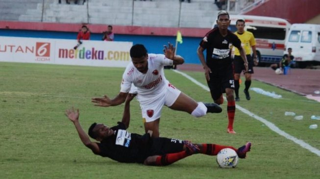 Pemain Persipura Gunansar Mandowen terjatuh saat berebut bola dengan pemain PSM Makassar Hasyim Kipuw saat bertanding di Stadion Gelora Delta Sidoarjo, Jawa Timur, Jumat (27/09/2019). (Foto Umarul Faruq)