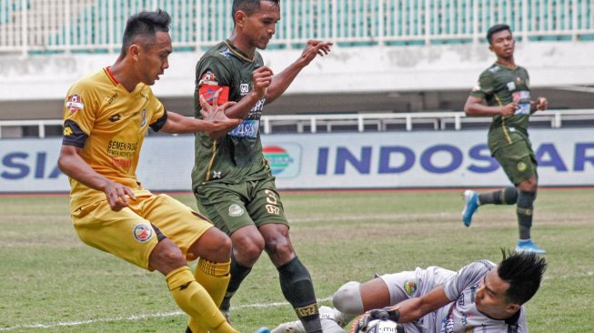Kiper Tira Persikabo Angga Saputro (kanan) menangkap tendangan pesepak bola Semen Padang Dedi Hartono (kiri) pada lanjutan Liga 1 2019 di Stadion Pakansari, Cibinong, Bogor, Jawa Barat, Jumat (27/9/2019). ANTARA FOTO/Yulius Satria Wijaya