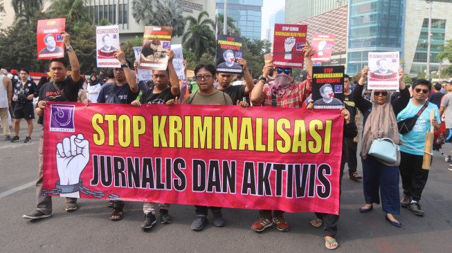 Sejumlah Jurnalis yang tergabung dalam Aliansi Jurnalis Independen (AJI) Jakarta menggelar aksi jalan mundur di Bundaran HI, Jakarta Pusat, Minggu (29/9). [Suara.com/Arya Manggala]