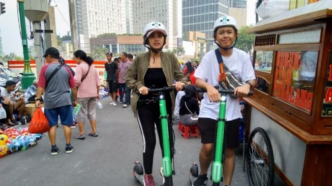 Pengguna layanan skuter listrik Grabwheels dari Grab di Jakarta, Minggu (29/9/2019). [Antara/Laily Rahmawaty]