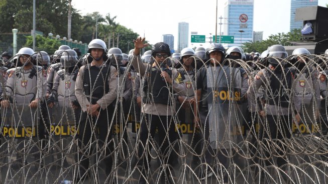 Petugas Kepolisian melakukan pengamanan di sekitar Gedung DPR RI, Jakarta, Senin (30/9). [Suara.com/Angga Budhiyanto]