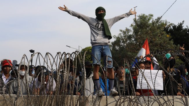 Sejumlah massa aksi yang tergabung dari aliansi mahasiswa, buruh dan pelajar menggelar aksi unjuk rasa di depan Gedung DPR RI, Senin (30/9). [Suara.com/Angga Budhiyanto]