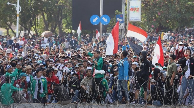 Sejumlah massa aksi yang tergabung dari aliansi mahasiswa, buruh dan pelajar menggelar aksi unjuk rasa di depan Gedung DPR RI, Senin (30/9). [Suara.com/Angga Budhiyanto]