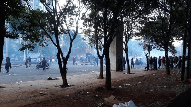 Polisi menembakkan gas air mata ke arah massa pelajar di dekat Stasiun Palmerah, Jakarta, Senin (30/9). (Suara.com/Novian)