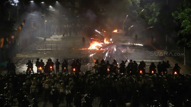 Polisi menembakkan gas air mata untuk membubarkan massa yang rusuh di Jalan Pejompongan, Jakarta Pusat, Senin (30/9). [Suara.com/Arya Manggala]