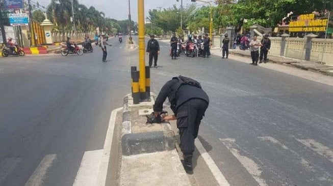 Salah satu petugas Jibom saat mengidentifikasi temuan tas hitam di depan Mako Brimob Polda Kalsel. (Kanalkalimantan.com).